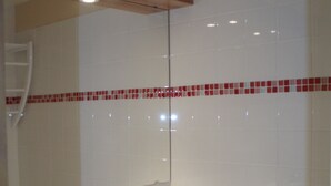 A bathroom with white tiles, a red and white mosaic border, a white bathtub, and a white sink. - Les Ménuires, on skis (Saint Martin de Belleville)