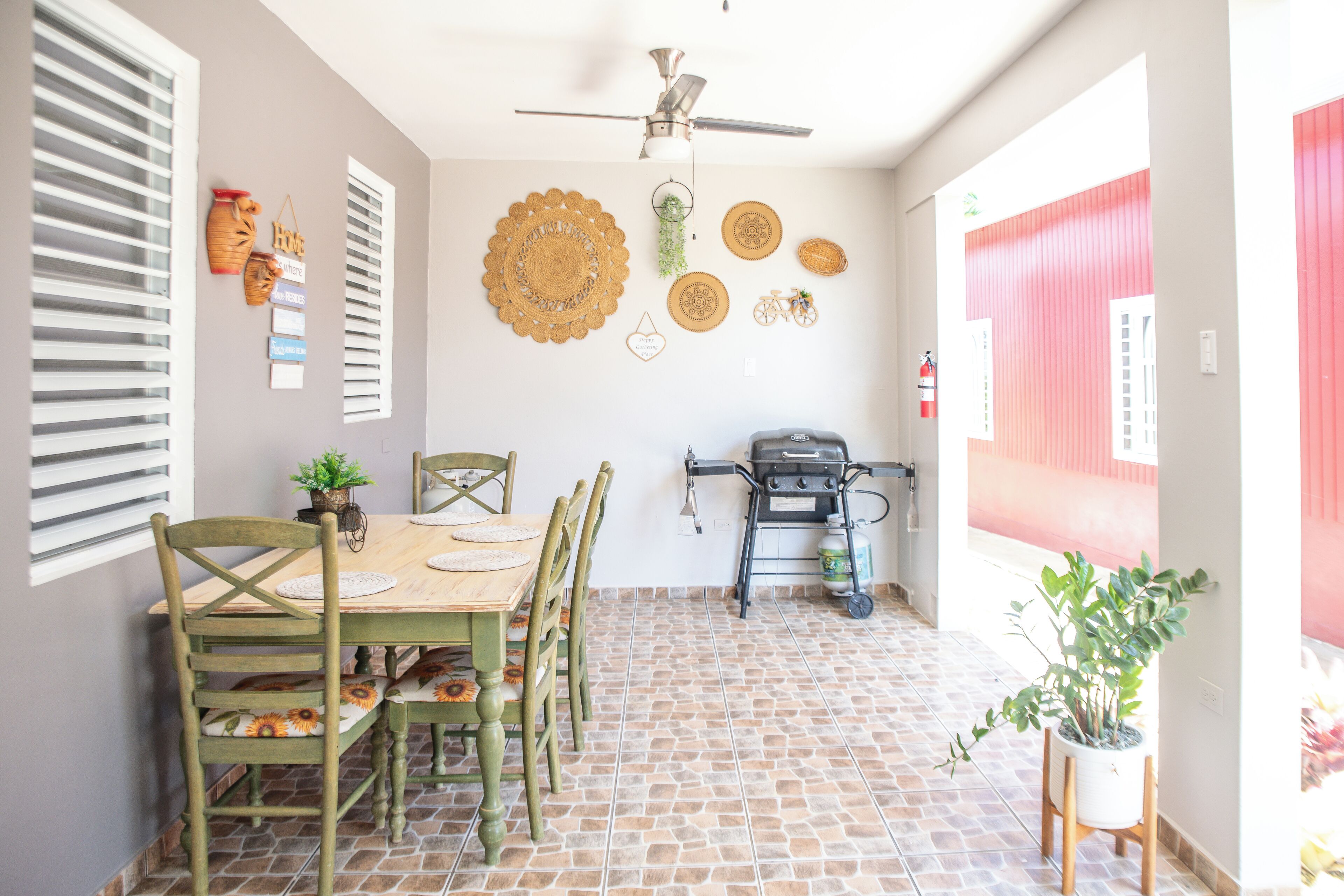 A dining area with a table, chairs, and a ceiling fan.