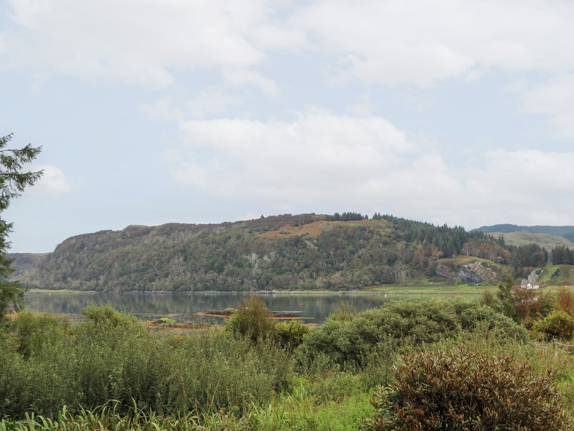 Un lac entouré de collines et d’une végétation luxuriante.