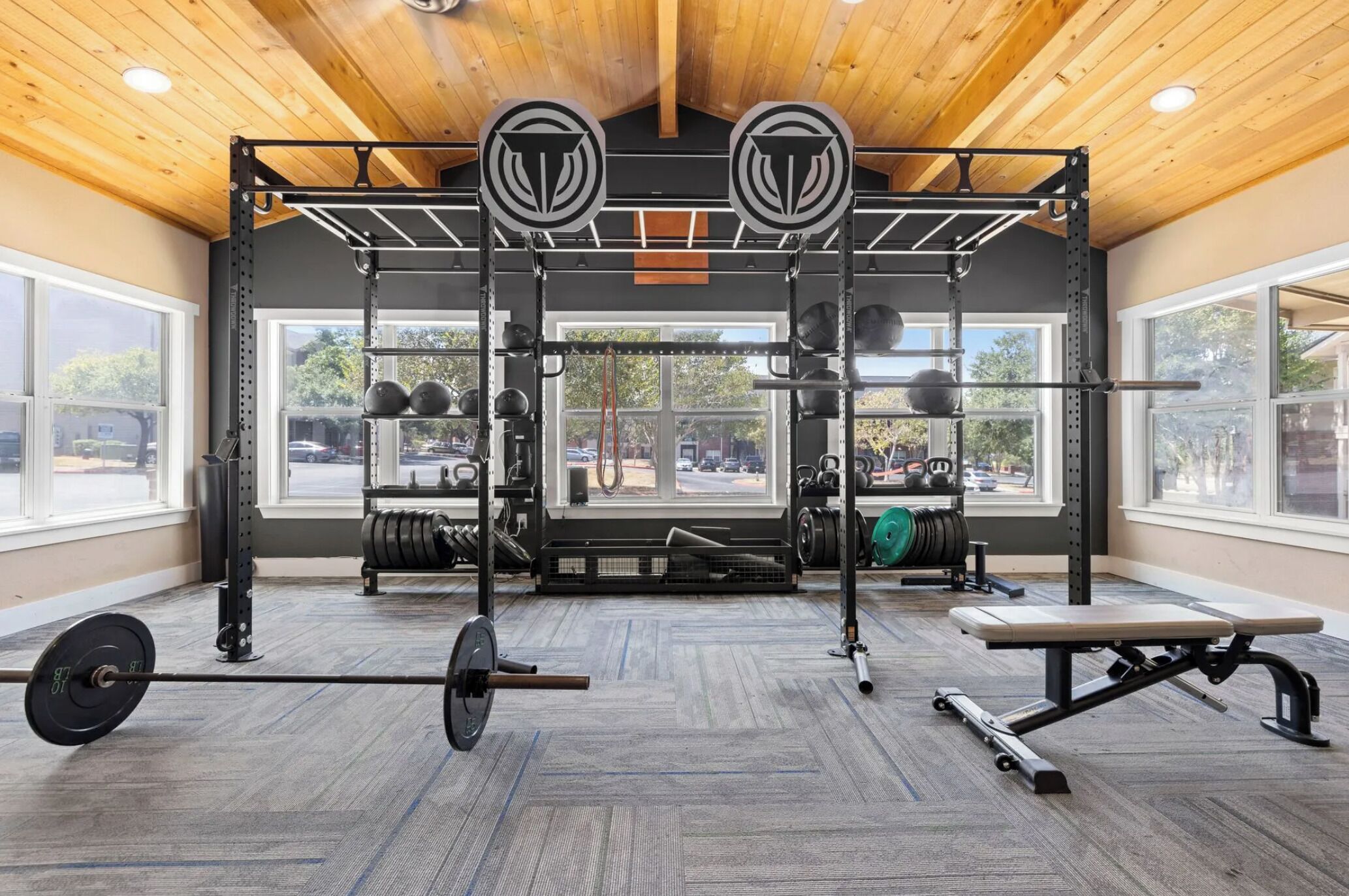 A gym with a pull-up bar, weight rack, and bench.