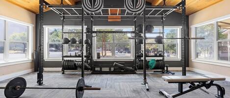A gym with a pull-up bar, weight rack, and bench.