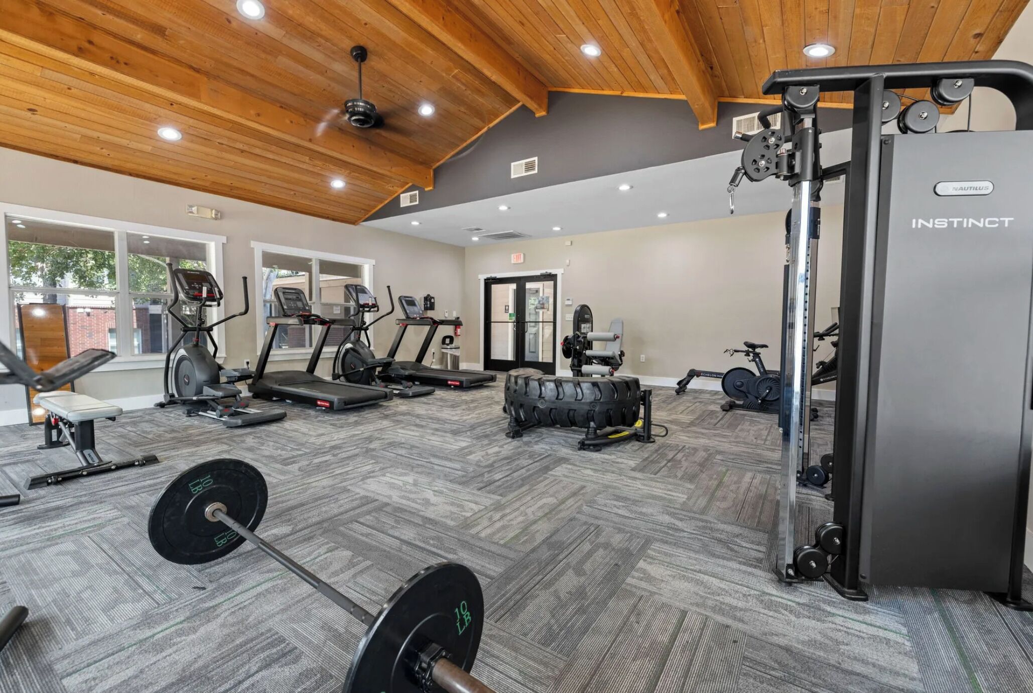 A gym with treadmills, weight machines, and a squat rack.