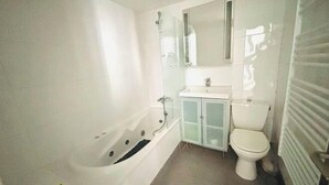 Un baño con bañera, inodoro y lavabo.