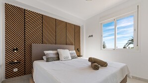 A bedroom with a bed, a patterned wall, a window, and a nightstand. - 'Marbella City Center Apartment' with Sea View, Shared Pool and Wi-Fi (Marbella)