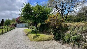 A gravel path leading to a building with a metal fence on one side. - 1 Bed Cabin-sleeps 2, Hot Tub, Garden, Pets, Views (Callington)
