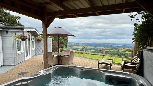 A hot tub with a view of a green landscape. - 1 Bed Cabin-sleeps 2, Hot Tub, Garden, Pets, Views (Callington)