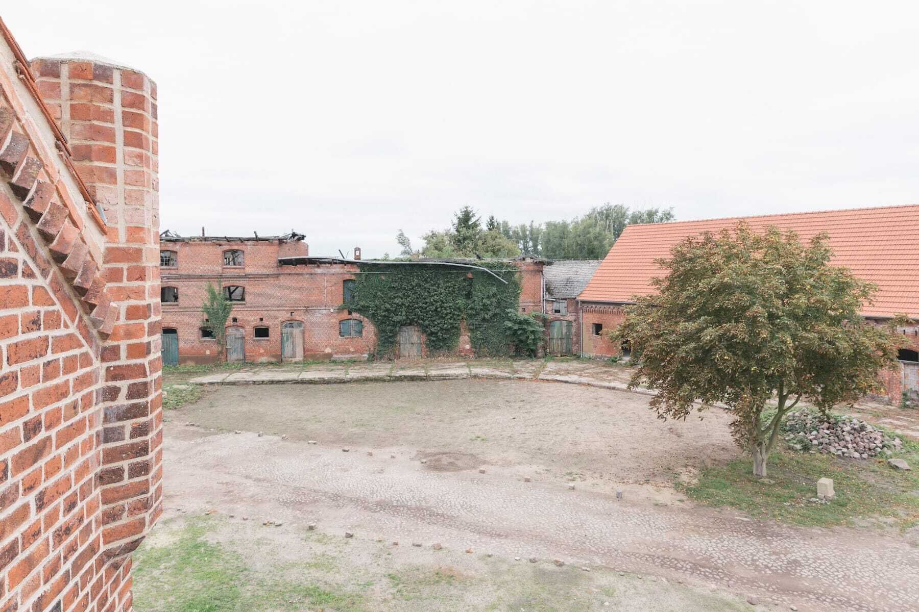 An abandoned building with brick walls and a courtyard.
