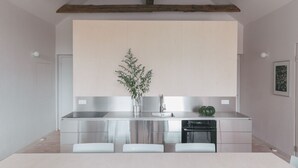 Een moderne keuken met roestvrijstalen apparatuur, een houten balk en een minimalistisch design.