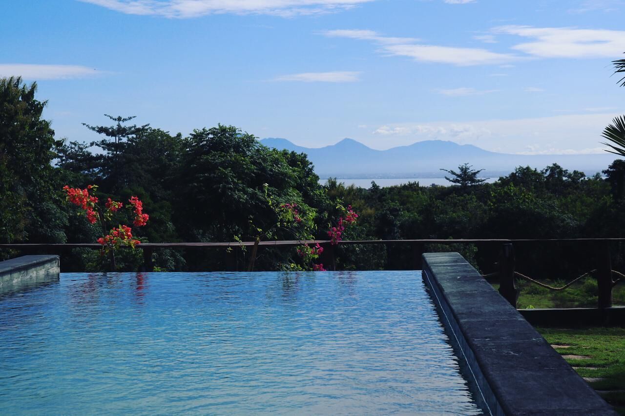 A swimming pool with a view of mountains and trees.