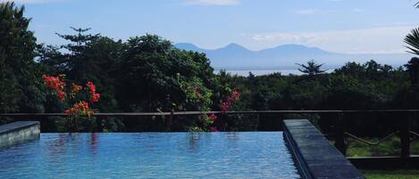 A swimming pool with a view of mountains and trees.