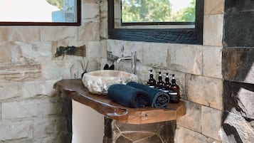 Een aparte badkuip en douche, handdoeken, zeep, shampoo