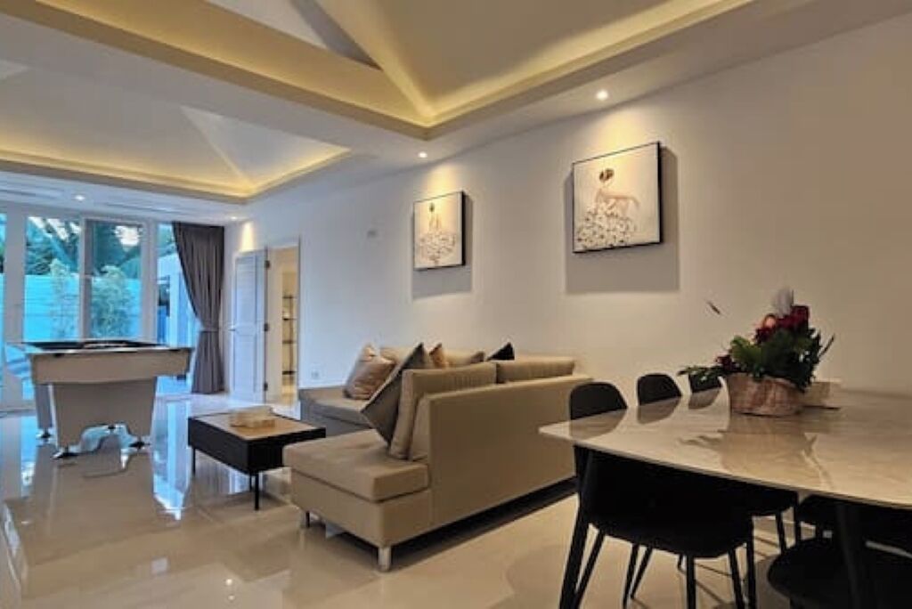 Una sala moderna con sofá, mesa de comedor y mesa de billar.