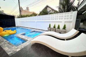 A swimming pool with a white lounge chair and yellow inflatable rings. - Villa 129 Wongamat, 4 Beds. (Pattaya City)