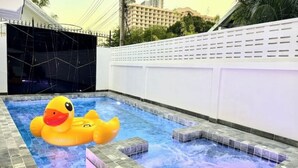 Une piscine avec un jacuzzi et un flotteur en forme de canard.