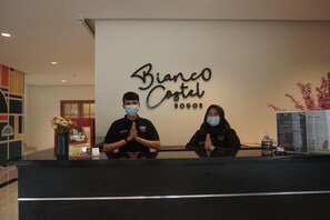 A reception desk with a sign reading 'Bianco Cottel Bogor' and a menu board to the right. - Bianco Costel (Central Bogor)
