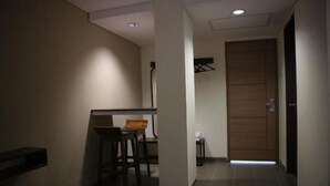 A hallway with a seating area, a door, and a small table. - Bianco Costel (Central Bogor)