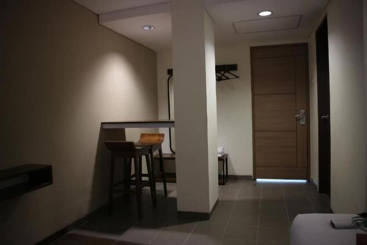 A hallway with a seating area, a door, and a small table.