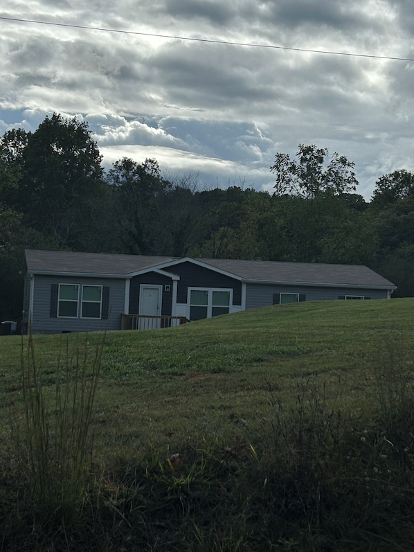 A two-story house with a sloped roof, a front porch, and a garage.