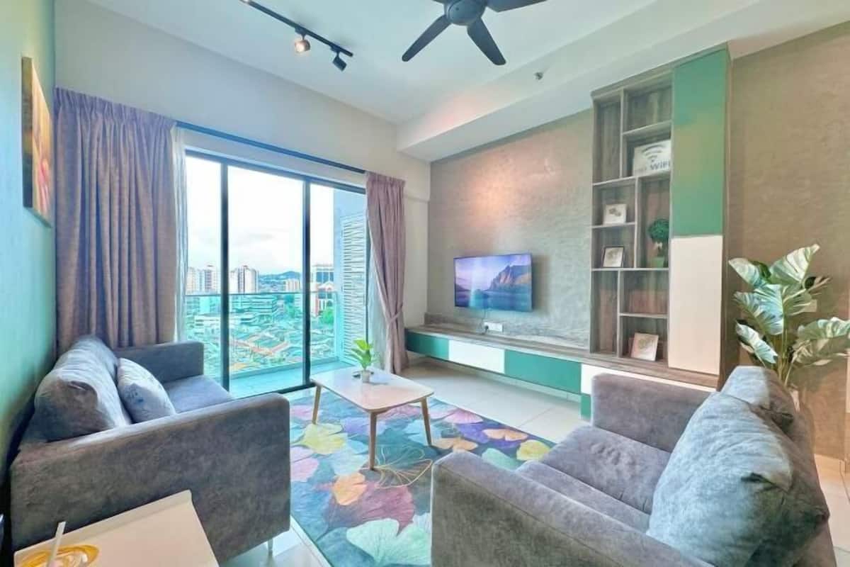 Ein modernes Wohnzimmer mit Sofa, Couchtisch und Fernseher an der Wand.