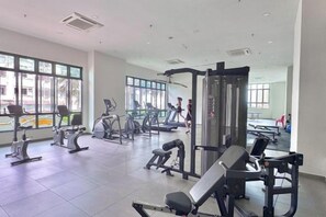 Ein Fitnessstudio mit unterschiedlichen Trainingsgeräten, großen Fenstern und hellem Innenraum.