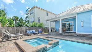 Un jardin avec une piscine, une clôture en bois et un patio couvert.