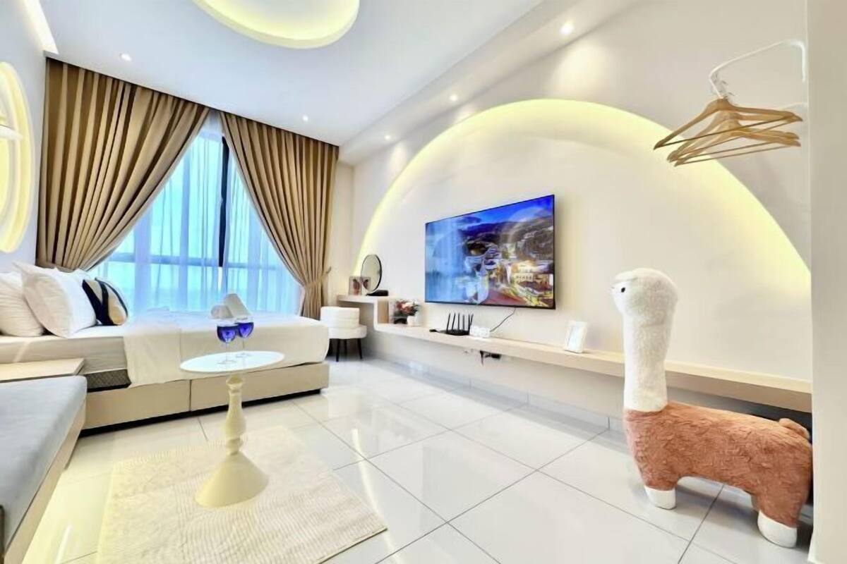 Un soggiorno moderno con un divano, un tavolino, una TV e una statuetta decorativa a forma di lama.