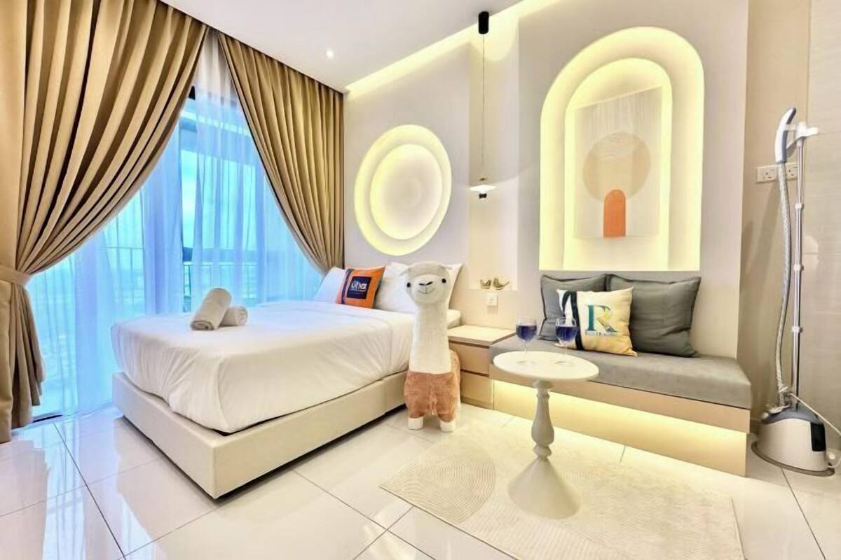 Una camera d'albergo moderna con un letto grande, un divano, un tavolino e uno spazio doccia.
