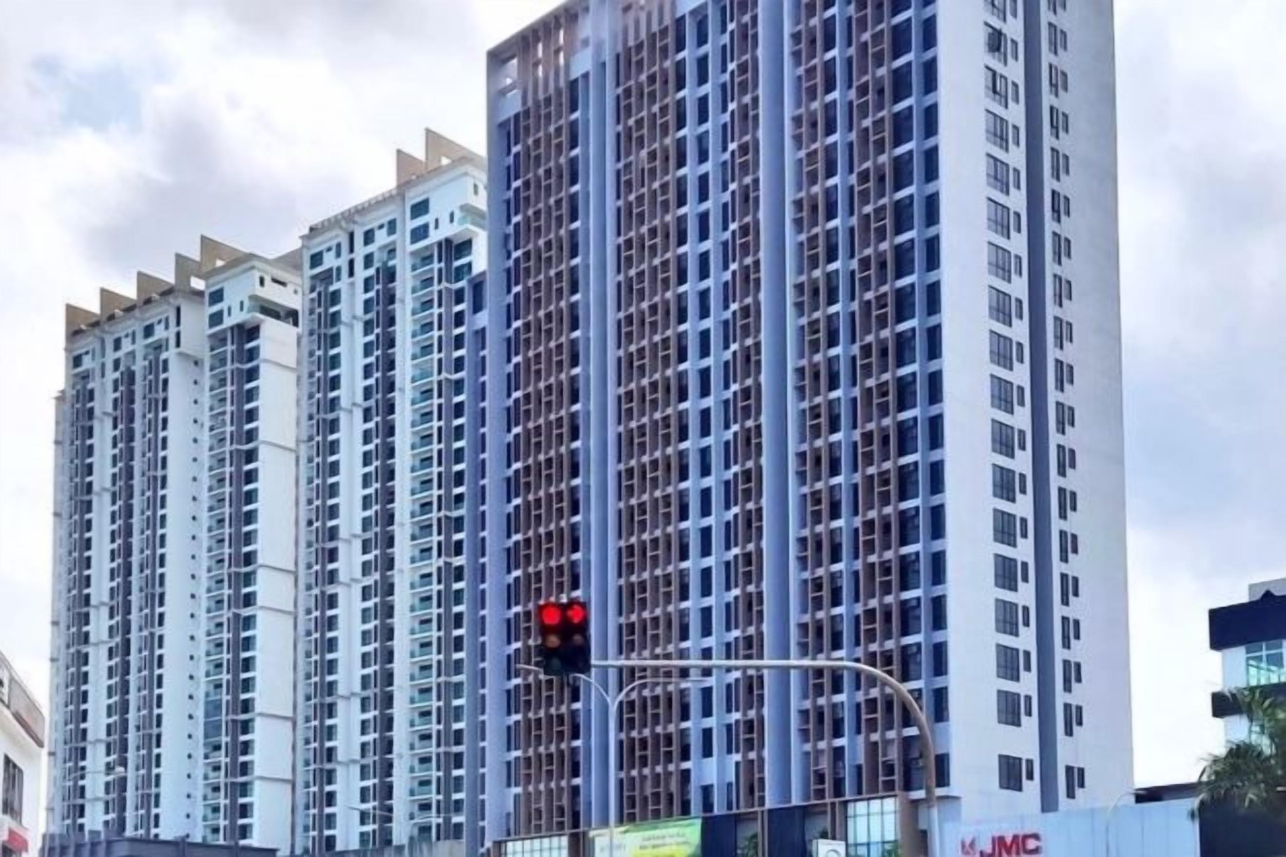 A high-rise building with multiple floors, a traffic light, and a partially visible sign with the letters 'JMC'.