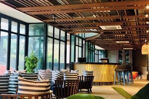 A modern interior with a reception desk, seating area, and large windows. - FLC Quy Nhon Beachfront Condotel (Quy Nhon)