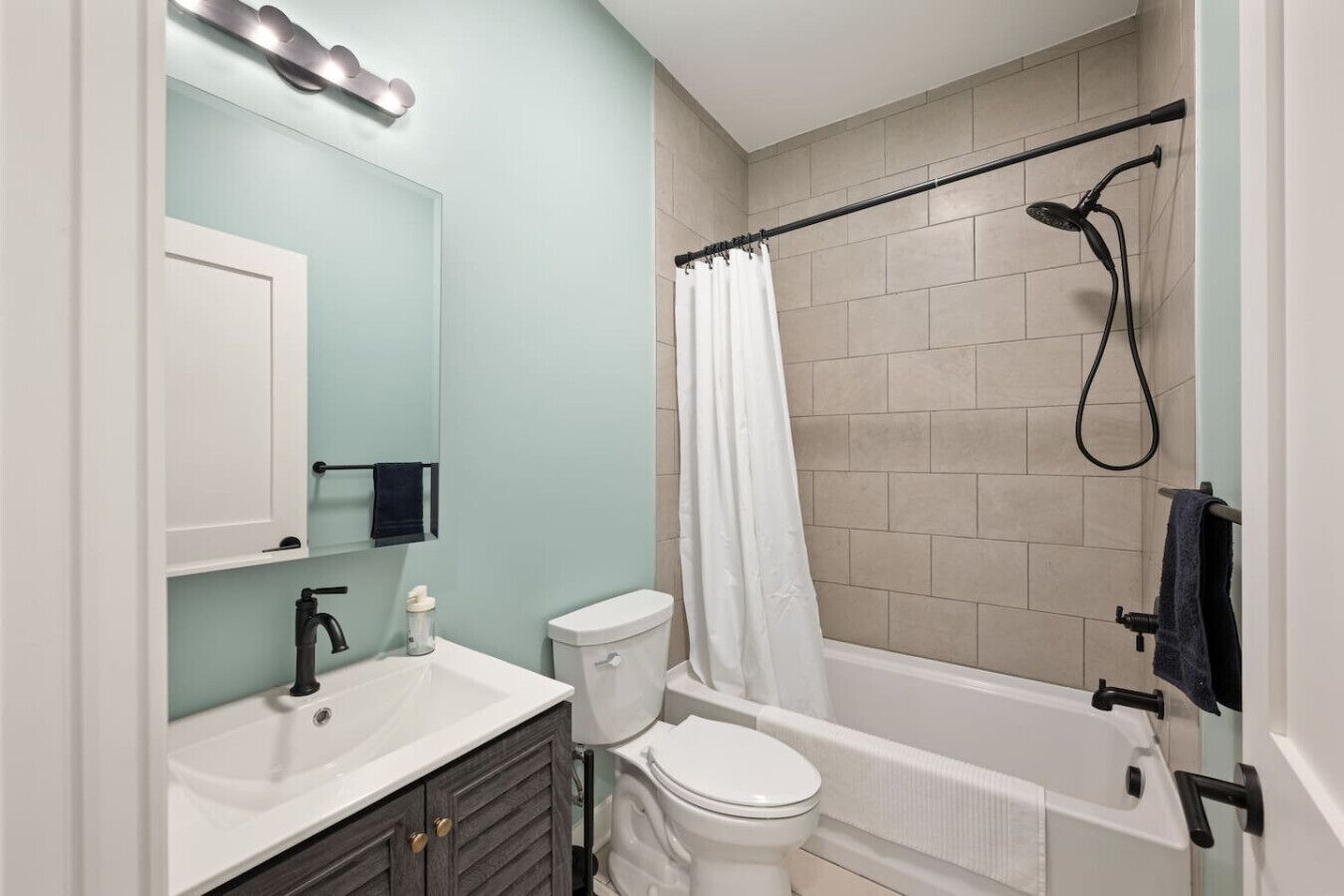 Een moderne badkamer met toilet, wastafel en bad.