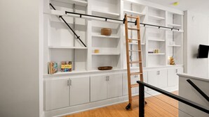 A modern interior with white cabinetry, a wooden ladder, and a black pull-down shelf system. - Lux Hidden Gem, 2bd w/ Patio Steps from All OTR (Cincinnati)