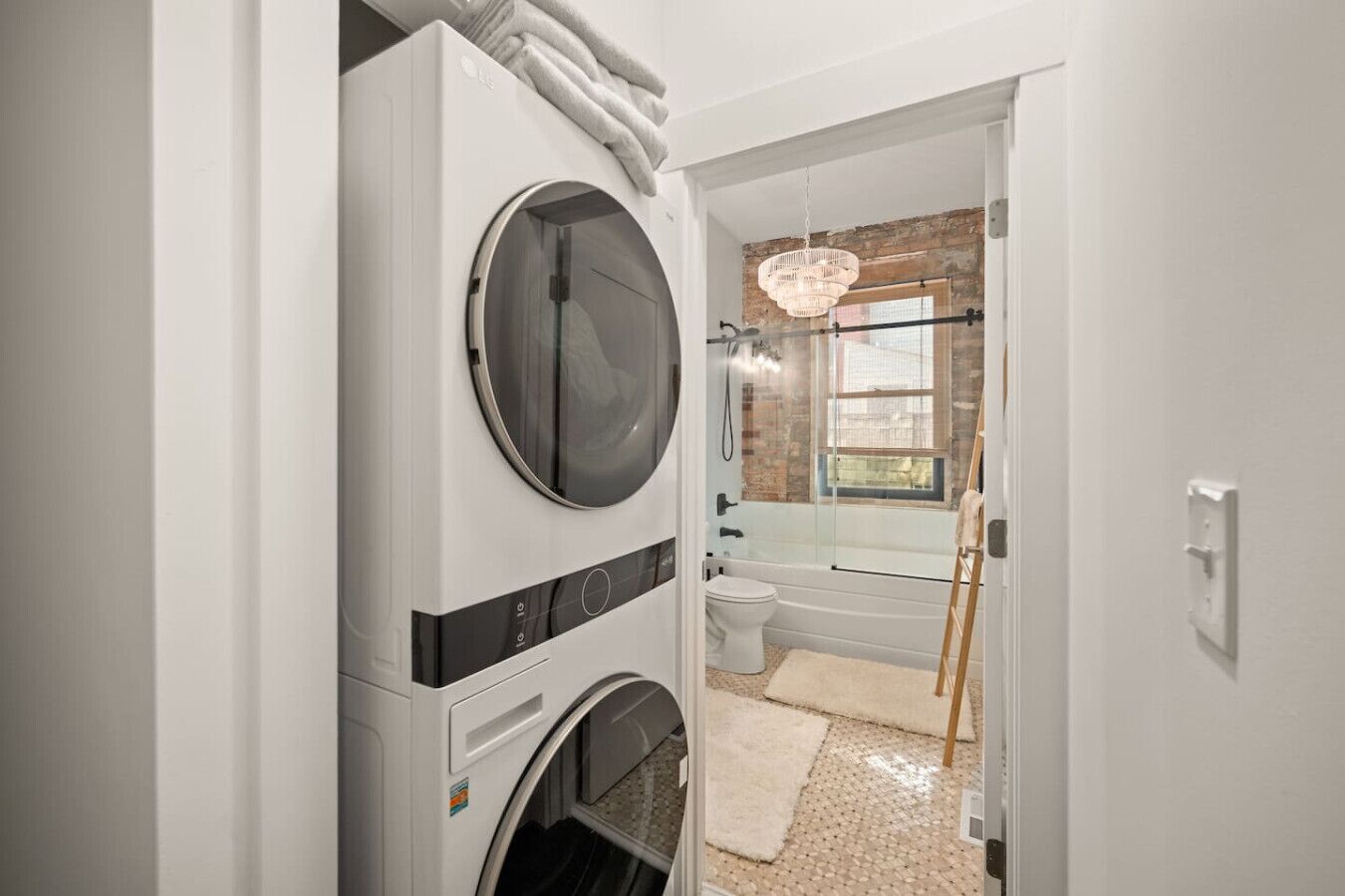 Une buanderie équipée de plusieurs sèche-linge superposés et d’une machine à laver.