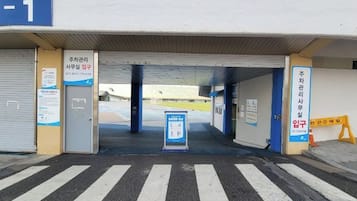 A covered entrance to a building with a blue sign indicating 'Gate / Entrée -1'.