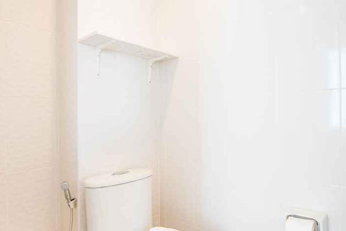 A bathroom with a toilet, a shower, and a towel rack.