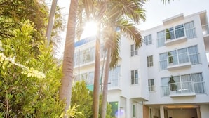 A modern building with multiple floors, balconies, and a courtyard with greenery. - Baan Kangmung HuaHin Resort (Hua Hin)