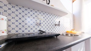 Una cocina con encimera negra, un lavamanos y un salpicadero con diseño.