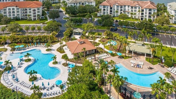 Un resort con una gran piscina, varias edificaciones y un estacionamiento.