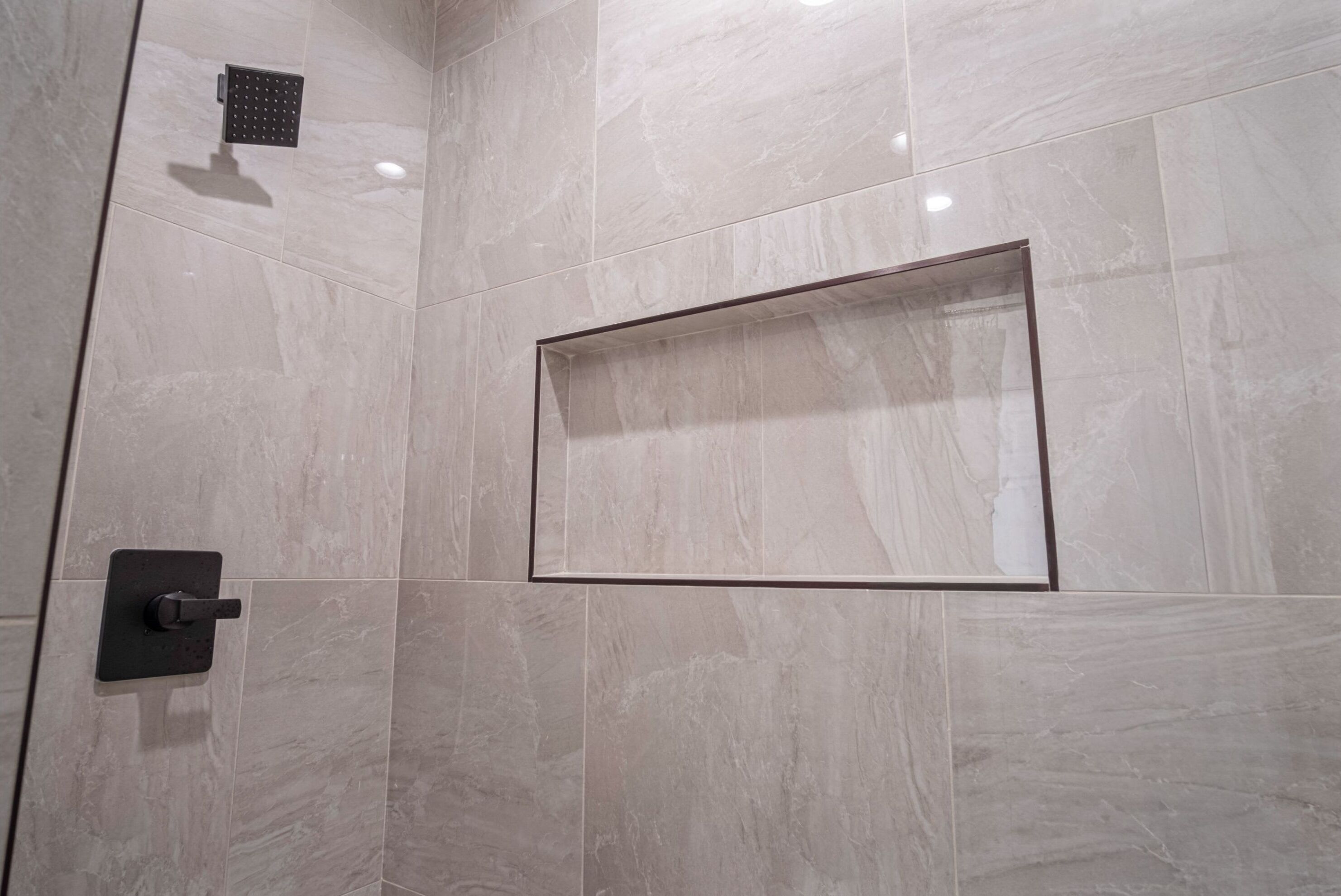Zona de bany moderna amb envàs de vidre rectangular i panell de control.