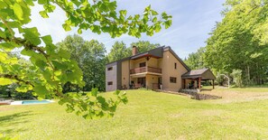 Une maison à deux étages dotée d’un balcon, d’une piscine et d’un espace extérieur couvert.