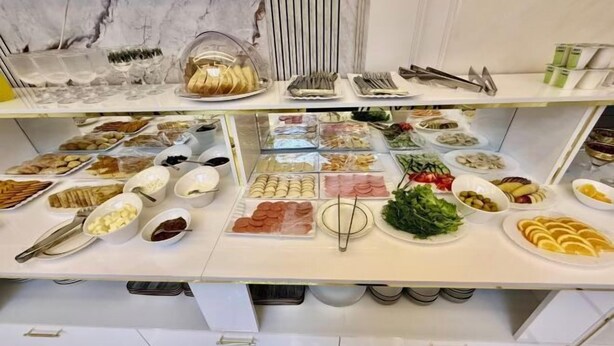 A buffet spread with various food items and utensils. - Isakhoja Hotel (Khiva)