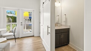 Een moderne badkamer met een grote spiegel, een wastafel en donkere kastjes.