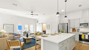Een moderne keuken met witte kastjes, roestvrijstalen apparatuur en een groot eiland.