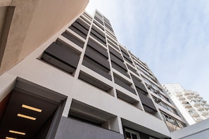Un moderno edificio de gran altura con varios pisos, ventanas amplias y un diseño arquitectónico limpio y minimalista.