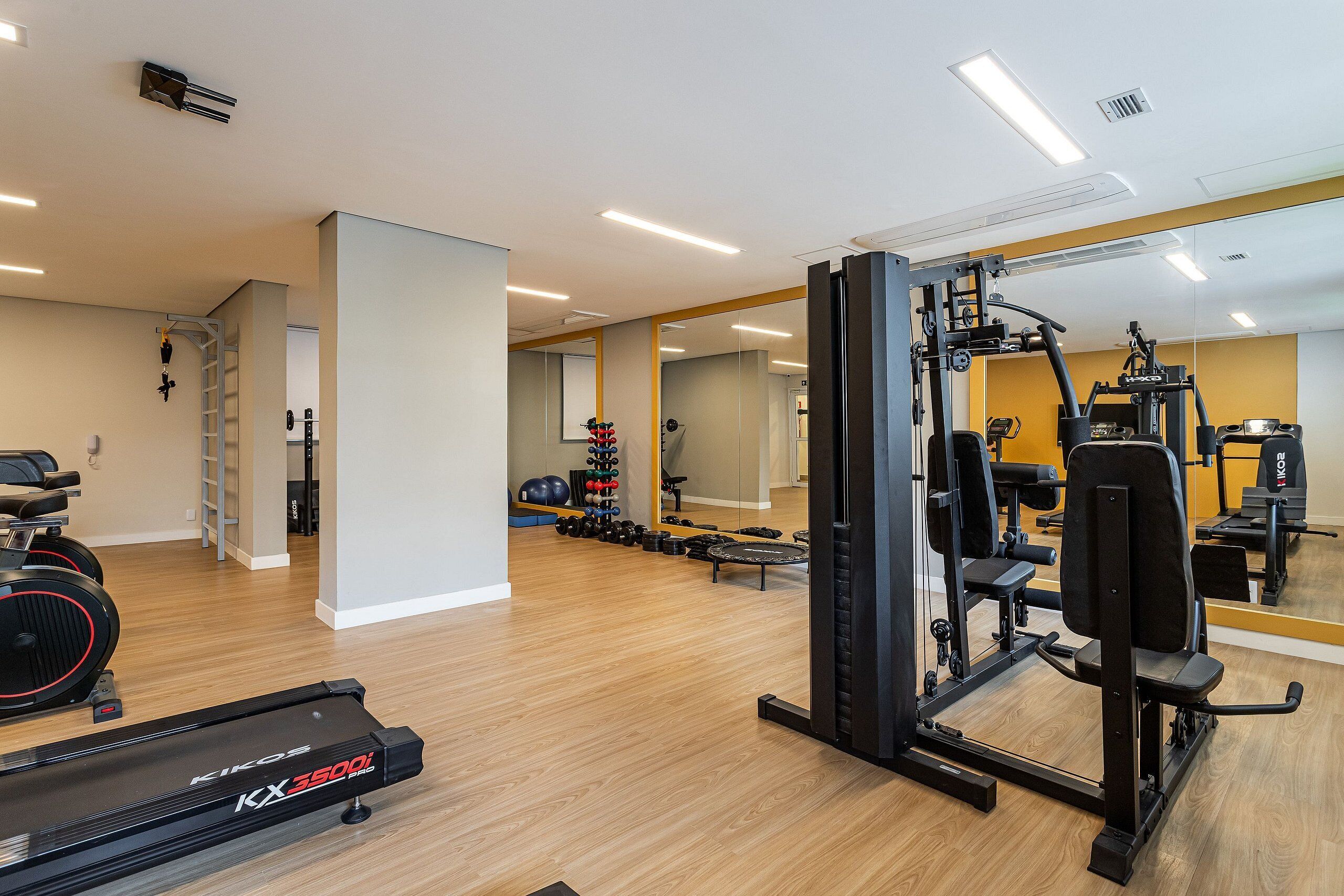 A gym with cardio equipment, weight machines, and free weights.