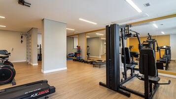 A gym with cardio equipment, weight machines, and free weights.