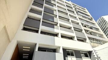 A modern high-rise building with a prominent entrance, numbered 965, and a gated driveway.