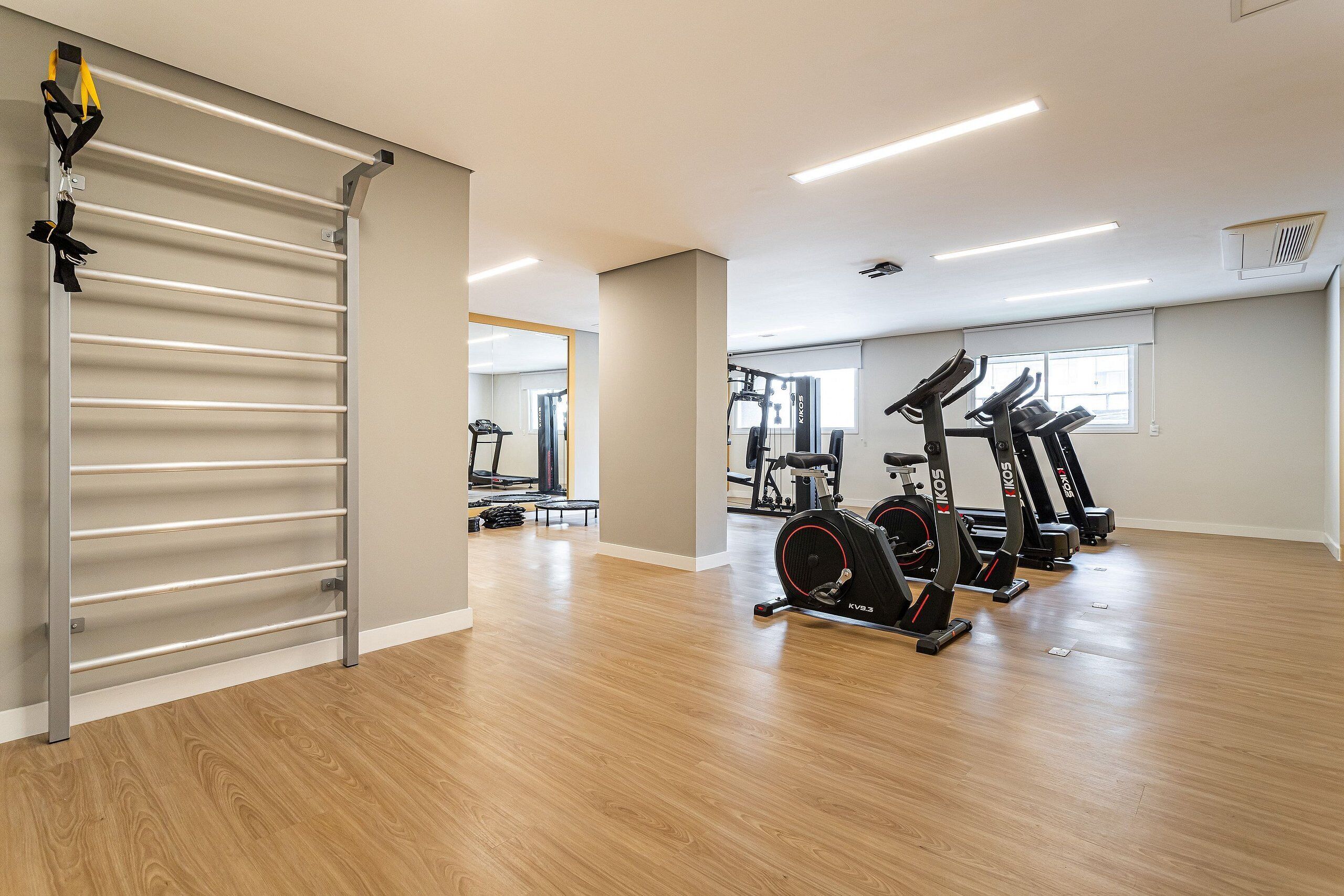 A gym with exercise equipment, including treadmills and a pull-up bar.