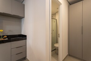 Een moderne badkamer met een glazen douchecabine, een toilet en een wastafel met een zwart aanrecht.