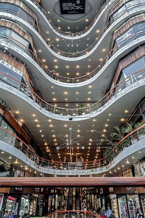 Um shopping center com vários níveis, passarelas curvas e diversas lojas.