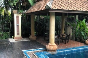 A covered outdoor area with a pool, columns, and seating. - Pichawaree Resort (Si Thep)